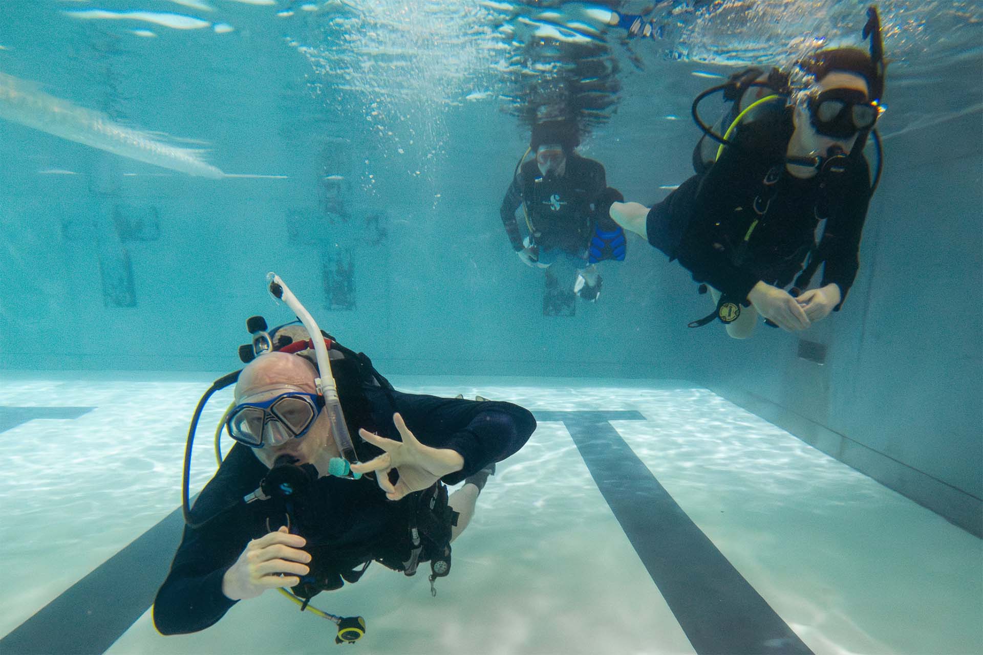 PADI scuba instructor teaching Open Water student proper skills in pool during Columbus Scuba beginner course
