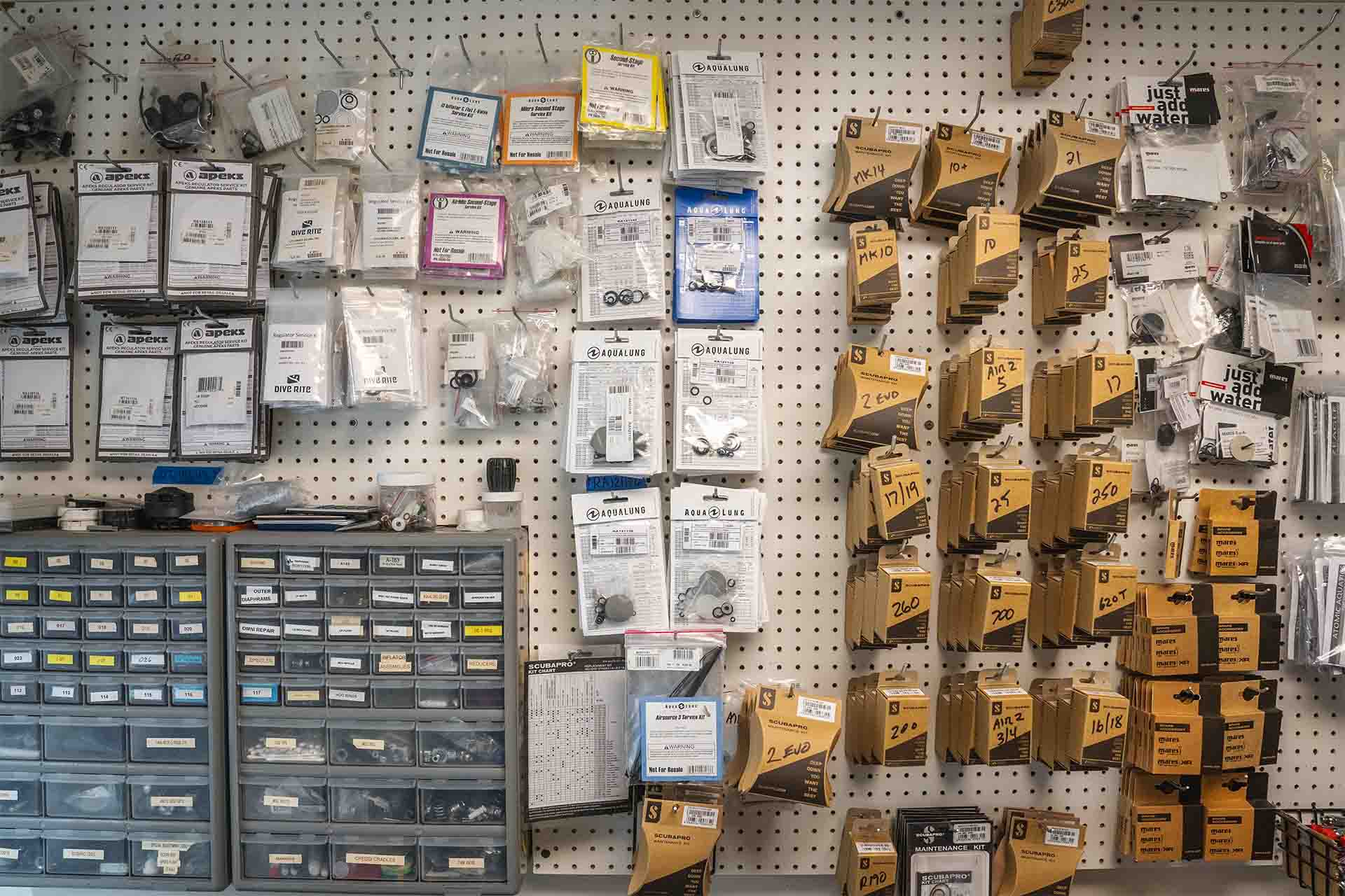Comprehensive parts inventory display with organized storage drawers labeled boxes and manufacturer parts at Columbus Scuba