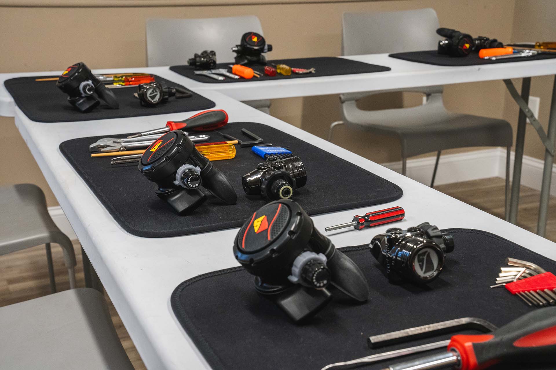 Dive equipment demonstration setup with regulators computers and tools for hands-on classroom training